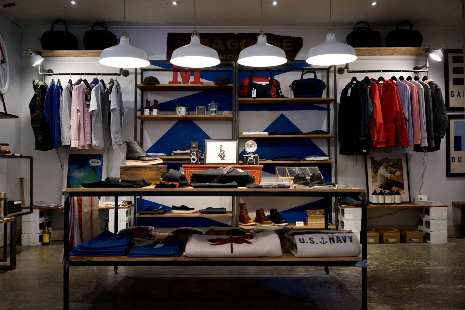 Independent retail interior with hanging garments, shelving and a central display table