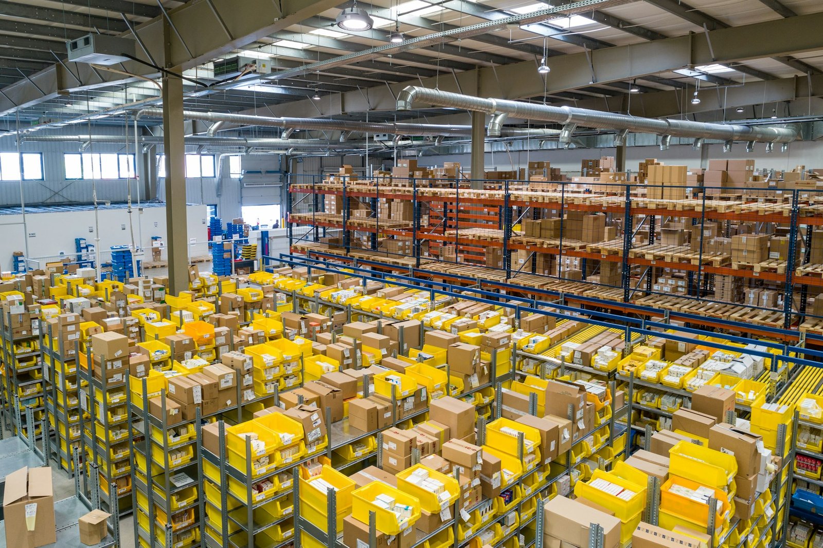 Warehouse aisles of cartons and yellow storage bins
